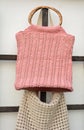 Beautiful crocheted old pink hand made handbags behind the wall