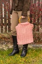 Beautiful crocheted old pink handbag with person behind red bush in autumn