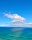 Beautiful cumulus clouds in a blue sky over a calm blue sea and ocean in summer. Gorgeous scenic view of the beach and Royalty Free Stock Photo