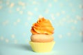 Beautiful cupcake on blue background with blurred lights. Birthday treat Royalty Free Stock Photo