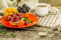 beautiful cupcakes with berries on wooden background in red plate Royalty Free Stock Photo