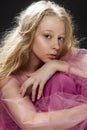 Beautiful curly blonde teenager child girl wearing a pink air dr Royalty Free Stock Photo