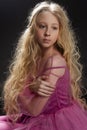 Beautiful curly blonde teenager child girl wearing a pink air dr Royalty Free Stock Photo