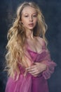 Beautiful curly blonde teenager child girl wearing a pink air dr