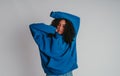 Beautiful curly-haired girl posing in a blue sweater and jeans on a white background Royalty Free Stock Photo