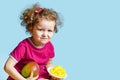 Beautiful curly happy girl with mango on blue background.