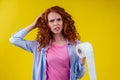 Beautiful curly redhead ginger woman holding eco toilet paper roll on yellow color background Royalty Free Stock Photo