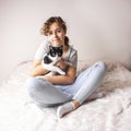 Beautiful curly teenager girl in the bed hugs her cat. Pet love. Animal care Royalty Free Stock Photo