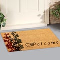 Beautiful cursive welcome peach color doormat with red and black flower plant Placed outside door with green leaves Royalty Free Stock Photo