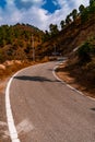 Beautiful curved roadway, rocks, stones, blue sky with clouds.