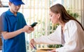 Beautiful customer receiving parcel at indoor home, rechecking, opening box sending by postal while delivery man taking photos for Royalty Free Stock Photo