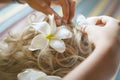 Beautiful, cute blond bride doing hair with flowers before wedding day. Long lashes, white flowers, smilling and happy. Royalty Free Stock Photo