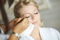 Beautiful, cute blond bride doing makeup before wedding day. Lon