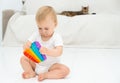 Beautiful cute caucasian interested baby girl sitting on floor at home playing with pop-it game on background of cat Royalty Free Stock Photo