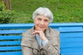 beautiful cute elderly woman sitting in park bench blue Royalty Free Stock Photo