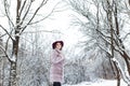 Beautiful cute elegant girl in a fur coat and hat walking in the winter forest bright frosty morning Royalty Free Stock Photo