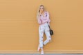 Beautiful cute funny amazing young hipster teen girl eating ice cream cone, laughs happy, bright casual wear, orange Royalty Free Stock Photo