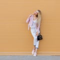 Beautiful cute funny amazing young hipster teen girl eating ice cream cone, laughs happy, bright casual wear, orange Royalty Free Stock Photo