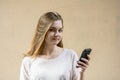 Beautiful cute girl on a beige background. Without anyone. Blond girl with green eyes. She looks at the camera and smiles. Busines Royalty Free Stock Photo