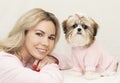 Beautiful cute girl holding a well groomed shih tzu puppy in a pink sweater Royalty Free Stock Photo