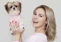 Beautiful cute girl holding a well groomed shih tzu puppy in a pink sweater Royalty Free Stock Photo