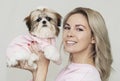 Beautiful cute girl holding a well groomed shih tzu puppy in a pink sweater Royalty Free Stock Photo