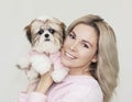 Beautiful cute girl holding a well groomed shih tzu puppy in a pink sweater Royalty Free Stock Photo