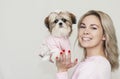 Beautiful cute girl holding a well groomed shih tzu puppy in a pink sweater Royalty Free Stock Photo