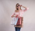 Beautiful cute girl with person shopping bags in jeans sunglasses studio