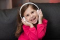 Beautiful Cute Happy Little Girl Listens To Music On Wireless Headphones. Funny Little Girl Dancing, Singing And Moving Royalty Free Stock Photo