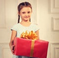 Beautiful cute kid girl holding big present box with red ribbon Royalty Free Stock Photo