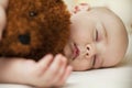 Cute little baby sleeping in a sweet sleep hugging a bear Royalty Free Stock Photo