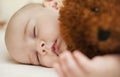 Cute little baby sleeping in a sweet sleep hugging a bear Royalty Free Stock Photo