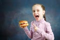 Beautiful Cute Little Caucasian Girl Is Shows A Hamburger In Her Hand