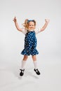 Beautiful cute little girl, child in retro style dress jumping, posing against grey studio background. Concept of Royalty Free Stock Photo