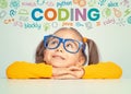 Beautiful cute little girl with eyeglasses looking at colorful CODING word and symbols above her headBeautiful cute little girl wi