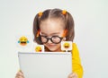 Beautiful cute little girl with glasses using tablet computer on white background. Social media concept. Royalty Free Stock Photo