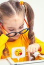 Beautiful cute little girl with glasses using tablet computer on white background. Social media concept. Royalty Free Stock Photo