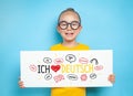 Beautiful cute little girl holding a white paper with message with i love german text Royalty Free Stock Photo