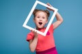 Beautiful cute little girl in pink dress holds picture frame Royalty Free Stock Photo