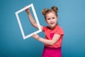 Beautiful cute little girl in pink dress holds picture frame Royalty Free Stock Photo