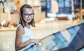 Beautiful cute little girl studying orientation plan in shopping mall. Shopping Center Store Guide. Modern touch screen technology