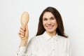 beautiful cute pleasant woman with long black hair stands holding a wooden comb in her hands and points her finger at