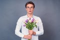 Cute and romantic guy with a bouquet of white and pink tulips Royalty Free Stock Photo