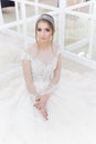 Beautiful cute tender young girl bride in wedding dress in mirrors with evening hair and gentle light make-up Royalty Free Stock Photo