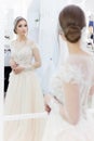 Beautiful cute tender young girl bride in wedding dress in mirrors with evening hair and gentle light make-up Royalty Free Stock Photo