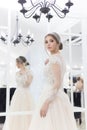 Beautiful cute tender young girl bride in wedding dress in mirrors with evening hair and gentle light make-up Royalty Free Stock Photo