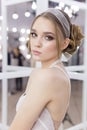 Beautiful cute tender young girl bride in wedding dress in mirrors with evening hair and gentle light make-up Royalty Free Stock Photo