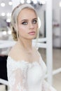 Beautiful cute tender young girl bride in wedding dress in mirrors with evening hair and gentle light make-up Royalty Free Stock Photo