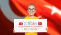 Beautiful cute Turkish girl holding a white paper with national holiday celebration message in front of turkey flag. 23 Nisan Kutl